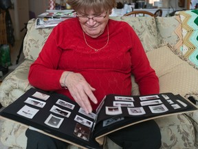 Denise Love looks through one of her photo albums in her living room. She has many photos of friends, family and some of herself over the year. Some of the people in photos she doesn't recognize. 
Photo by Sarah Taylor