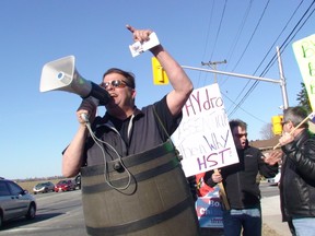 Guy Annable wields a megaphone and dons a barrel in a protest against high hydro rates and delivery prices  at a public event hosted by Ottawa West-Nepean MPP Bob Chiarelli on Thursday, April 24, 2014.
AEDAN HELMER /OTTAWA SUN/QMI AGENCY