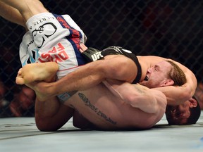 Tim Elliot (bottom) is submitted by Joseph Benavidez during the first round of UFC 172 at Baltimore Arena. (Tommy Gilligan/USA TODAY Sports)