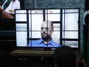 Saif al-Islam Gaddafi, son of deposed leader Muammar Gaddafi, is seen on a screen via video-link in a courtroom in Tripoli as he attends a hearing behind bars in a courtroom in Zintan, April 27, 2014. REUTERS/Ismail Zitouny