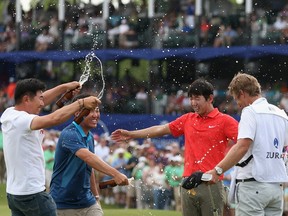 Seung-Yul Noh celebrates with golfers Charlie Wi and Y.E. Yang and his caddy Scott Saitinac after his win at the Zurich Classic of New Orleans on April 26, 2014 in Avondale, Louisiana. (Chris Graythen/Getty Images/AFP)