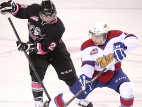 Calgary Hitmen Kenton Helgesen fights for the puck with Edmonton Oil Kings Blake Orban in WHL action at the Scotiabank Saddledome in Calgary, Alberta, on Jan. 26, 2014. Mike Drew/Calgary Sun/QMI AGENCY