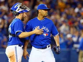 Catcher Josh Thole (left) and pitcher Esmil Rogers celebrate the Jays’ win over the Red Sox yesterday. (AbelImages.Getty Images)