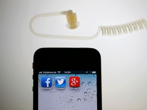 The application icons of Facebook, Twitter and Google are displayed on an iPhone next to an earphone set in this illustration photo.  REUTERS FILE/Pawel Kopczynski