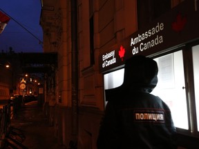 A Russian police officer stands guard outside the Canadian embassy in Moscow, April 22, 2014. REUTERS/Artur Bainozarov