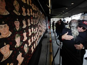 Chuck Vernelli, whose son Scott Vernelli was killed in Afghanistan March 20, 2009, hugs artist Dave Sopha at the unveiling of the The Portraits of Honour Tour,  featuring portraits of Canadian Forces members who lost their lives in Afghanistan on Parliament Hill. (JOHN MAJOR/QMI AGENCY file photo)