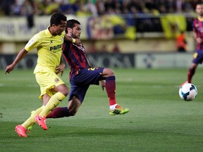 Barcelona's Dani Alves (right) and Villarreal's Giovani Dos Santos (left fight for the ball during their Spanish first division match at the Madrigal stadium in Villarreal, Spain, Sunday, April 27, 2014. (Heino Kalis/Reuters)
