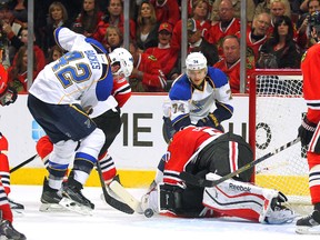 David Backes and T.J. Oshie of the St. Louis Blues try to jam the pucks past Chicago Blackhawks goalie Corey Crawford during Game 6 of their Western Conference playoff series on Sunday. (Dennis Wierzbicki-USA TODAY Sports)