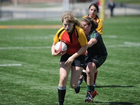 Sian Lloyd of Sydenham tries to elude a Holy Cross player during a Kingston Area girls rugby match at Nixon Field on Monday. Sydenham won 22-17. (Justin Greaves/For The Whig-Standard)