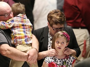 JOHN LAPPA/THE SUDBURY STAR/QMI AGENCY Eddie and Sue Rochette embrace their grandchildren, Skyler and Isabella, at a Day of Mourning ceremony at the Steelworkers Hall in Sudbury, ON. on Monday. Rochette's son, Paul, was killed at Vale's Copper Cliff smelter on April 6, 2014.