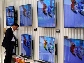 A customer looks at LG Electronics' TV sets which are made with LG Display flat screens at its store in Seoul Jan. 23, 2014.  REUTERS/Kim Hong-Ji