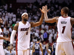 Miami Heat forward LeBron James (center) celebrates with center Chris Bosh (right) and guard Dwyane Wade (left) against the Charlotte Bobcats in game two during the first round of the 2014 NBA Playoffs at American Airlines Arena on Apr 23, 2014 in Miami, FL, USA. (Steve Mitchell/USA TODAY Sports)