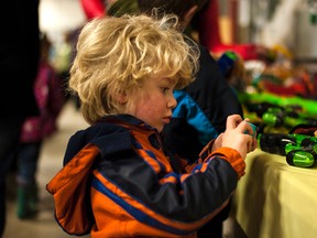 Jonah Gould, 3, examines toys at the Rotary Garage Sale this past weekend. @StandardBryan