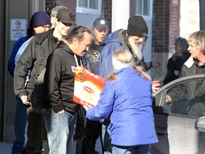 Ron and Marsha Eldridge of Devoted To You Ministries hand out hot chocolate and doughnuts to less fortunate people outside Siloam Mission last month. On Tuesday, the United Way proposed a four-point plan to reduce Winnipeg's homeless population. (Brian Donogh/Winnipeg Sun file photo)