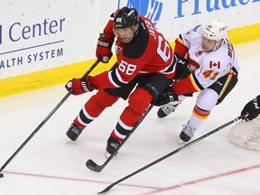 New Jersey Devils right wing Jaromir Jagr (68) protects the puck from Calgary Flames defenseman Chad Billins (41) during the third period at Prudential Center on Apr 7, 2014 in Newark, NJ, USA. (Ed Mulholland/USA TODAY Sports)