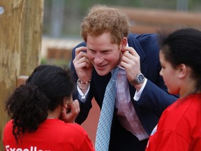 Britain's Prince Harry jokes with children as he and Mayor of London Boris Johnson (not pictured) viewed the Queen Elizabeth Olympic Park ahead of its opening on Saturday at Stratford in east London April 4, 2014.  REUTERS/Luke MacGregor