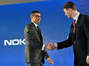 The new president and chief executive officer of Nokia Rajeev Suri (L) shakes hands with chairman of the board of directors and interim CEO of Nokia, Risto Siilasmaa during a news conference where Nokia announced first quarter earnings in Espoo April 29, 2014.  REUTERS/Heikki Saukkomaa/Lehtikuva