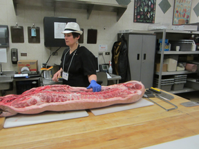 At Eat Alberta, butcher Elyse Chatterton prepares to carve up a full side of pork. (SUPPLIED)
