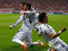 Real Madrid's Sergio Ramos (L) celebrates his goal against Bayern Munich with teammates Pepe (R) and Gareth Bale during their Champions League semi-final second leg soccer match in Munich April 29, 2014.    (REUTERS)