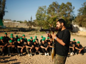 A Hamas militant teaches young Palestinians on how to use an rocket-propelled grenade (RPG) launcher at a military-style exercise run by Hamas during summer vacation in Gaza