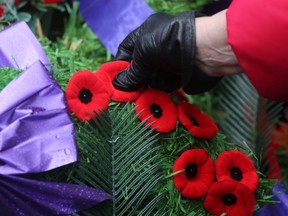 Members of the public place their poppies on the wreaths at the cenotaph. 

Jack Boland/QMI AGENCY