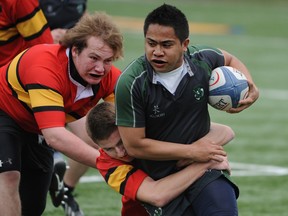 Andre Castilla of the Holy Cross Crusaders fights through the defence of Owen Embury and Colton Halligan of the Sydenham Golden Eagles during a Kingston Area senior boys rugby game at Nixon Field on Tuesday. (Justin Greaves/For The Whig-Standard)