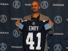 The Argonauts’ new middle linebacker Shea Emry holds up his new Double Blue jersey yesterday at the Argos’ head office. (ARGONAUTS.CA)