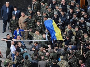 Members of Ukraine's State Security Administration (top) clash with members of the Euromaidan movement's self-defence units during a rally outside the cabinet of ministers building in Kiev April 30, 2014. REUTERS/Andrew Kravchenko