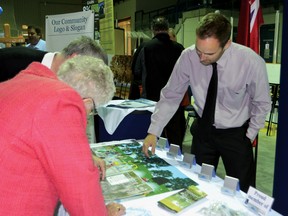 Andrew Meyer, Community Development Officer,  shows some of the diagrams of the outdoor pool to an interested couple