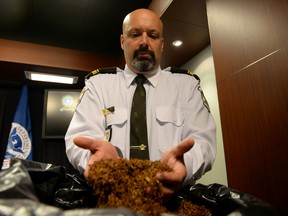 Lieut. Guy Lapointe of the Sûreté du Québec, shows a sample of the contraband tobacco seized during the searches. (MAXIME DELAND / Postmedia Network)