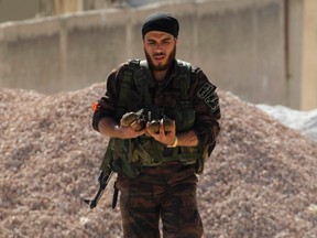 A rebel fighter carries hand grenades as he walks in Bureij neighbourhood of Aleppo April 30, 2014. 

REUTERS/Jalal Al-Mamo