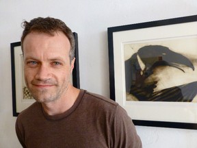 Guelph-based artist Ryan Price poses with a print from a series of illustrations appearing in his children's book. He was tasked with creating the art for the Kids Can Press' publication of "The Raven," a well-known poem by Edgar Allan Poe. SUBMITTED PHOTO