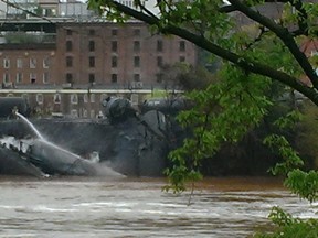 Emergency personnel attend to a CSX Corp train carrying crude oil that derailed and burst into flames in downtown Lynchburg, Virginia, April 30, 2014. 

REUTERS/WSET/Handout via Reuters