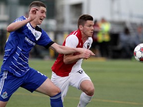 FC Edmonton's Marco Aleksic (25) and Ottawa Fury FC's Carl Haworth (17) chase down a loose ball during a game in Edmonton on April 30. The Fury  lost a close one 2-1 to Atlanta on Saturday, May 3, 2014.
(David Bloom/Edmonton Sun/QMI Agency)