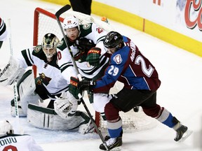 Colorado Avalanche centre Nathan MacKinnon and Minnesota Wild defenceman Ryan Suter battle for the puck in front of goalie Darcy Kuemper during Game 7 of their Western Conference quarterfinal series at the Pepsi Center in Denver, April 30, 2014. (RON CHENOY/USA Today)