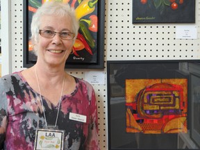 Susan Shurish, Lambeth Art Association member, stands beside one of her paintings.