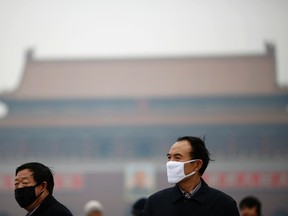 People wearing masks are seen on a hazy day at Tiananmen Square in Beijing February 13, 2014.
 REUTERS/Kim Kyung-Hoon