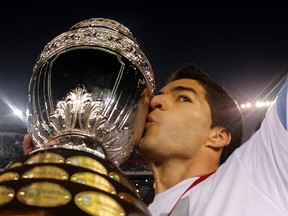 Uruguay's Luis Suarez kisses the trophy after winning the Copa America final soccer match against Paraguay in Buenos Aires, July 24, 2011.  (REUTERS/Enrique Marcarian)