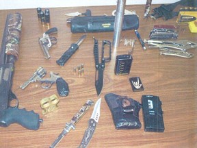 This photo, supplied by Hanover Police Service, shows the items they seized when arresting a Brockton man Monday night at a Hanover motel. Included are: a sawed-off shotgun, two .32 calibre revolvers, switchblades, brass knuckles, stiletto knife, ammunition, expandable baton, break-and-enter tools and a recording device.