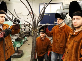 SCITS welding students Jordan Elnicki, Tyler Thevenot, Aaron Blondin and Mitch McCabe prepare to put the finishing touches on their metal tree. (CARL HNATYSHYN, The Observer)