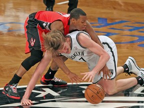 Raptors guard Kyle Lowry and Nets forward Andrei Kirilenko fight for a loose ball during Friday night’s game in Brooklyn. (USA TODAY SPORTS)