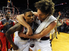 Damian Lillard (left) and Robin Lopez of the Portland Trail Blazers celebrate after defeating the Houston Rockets in Game 6 of their Western Conference quarterfinal series at the Moda Center in Portland, ay 2, 2014. (Getty Images)