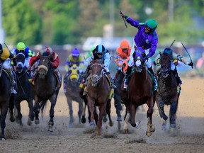 California Chrome, ridden by Victor Espinoza, crosses the finish line to win the 140th running of the Kentucky Derby at Churchill Downs on May 3, 2014. (Rob Carr/Getty Images/AFP)