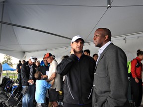Event chair Peter Ogilvie, left, talks with guest Donovan Bailey after the Edmonton International Track Classic was called off at Foote Field in Edmonton, Alta., on Wednesday, June 29 2011. Heavy rain delayed events and the threat of electrical storm was deemed too dangerous. AMBER BRACKEN/EDMONTON SUN  QMI AGENCY