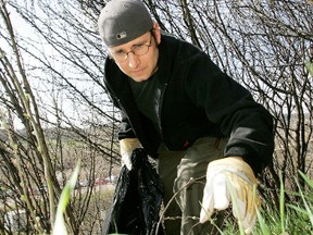 Tod Rudge climbs the riverbank near the Shaw Convention Centre collecting garbage in the 20th Annual River Valley Clean Up at Louise McKinney Riverfront Park yesterday. Sun file photo