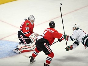 Chicago Blackhawks goalie Corey Crawford (50) makes a save on a shot by Minnesota Wild left wing Dany Heatley (right) as Blackhawks Niklas Hjalmarsson (4) looks on during the second period in Game 2 of the second round of the 2014 Stanley Cup Playoffs at United Center. (Jerry Lai-USA TODAY Sports)