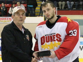 Wellington Dukes goalie Tyson Teichmann of Belleville accepts the tournament MVP award from 2014 Dudley Hewitt Cup co-chairman Don Cotton. (BRUCE BELL/The Intelligencer)