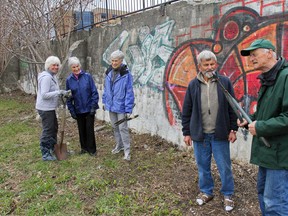 Mary Farrar, left, president of Friends of Kingston Inner Harbour, along with fellow volunteers Kathleen Satchell, Audrey Helmstaedt, Edward Farrar and Herb Helmstaedt, help clean up along a section of the retaining wall in Douglas Fluhrer Park on Saturday. The group is hoping to get an exemption from the city's graffiti bylaw for their planned On The Wall mural festival this August. Julia McKay/The Whig-Standard