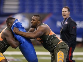 Former Miami offensive lineman Seantrel Henderson (right) runs a blocking drill with former Florida offensive lineman Jonotthan Harrison during the 2014 NFL Combine at Lucas Oil Stadium on February 22, 2014 in Indianapolis, Indiana. (Joe Robbins/Getty Images/AFP)