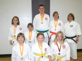 Seven athletes from the Pembina Renshikan Karate Club, shown here with coach Deb Ellard, show off some  of the 12 medals they won out of 14 events they took part in at a recent tournament.